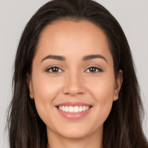 Joyful white young-adult female with long  brown hair and brown eyes