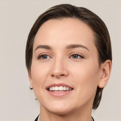 Joyful white young-adult female with medium  brown hair and grey eyes