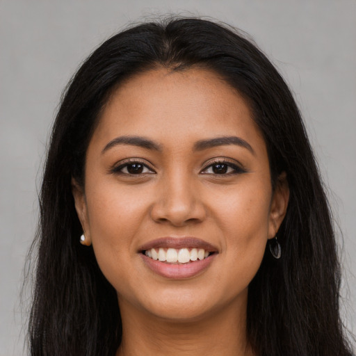 Joyful latino young-adult female with long  brown hair and brown eyes