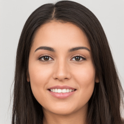 Joyful white young-adult female with long  brown hair and brown eyes