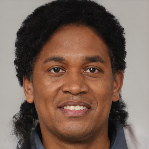 Joyful black adult male with short  black hair and brown eyes