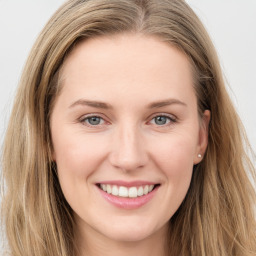 Joyful white young-adult female with long  brown hair and grey eyes