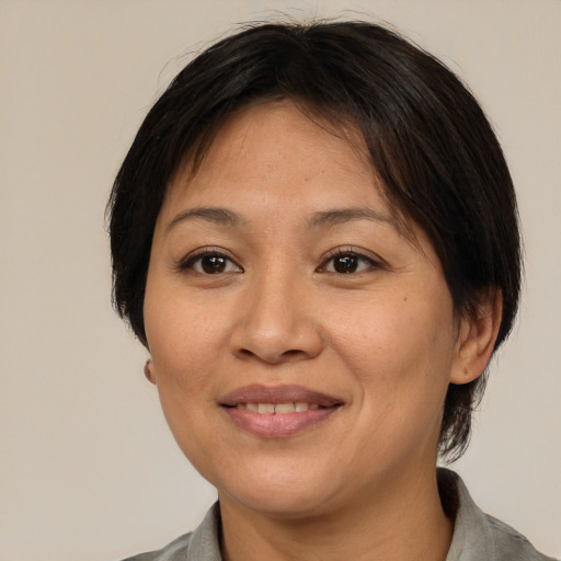 Joyful asian adult female with medium  brown hair and brown eyes