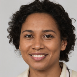 Joyful black adult female with medium  brown hair and brown eyes