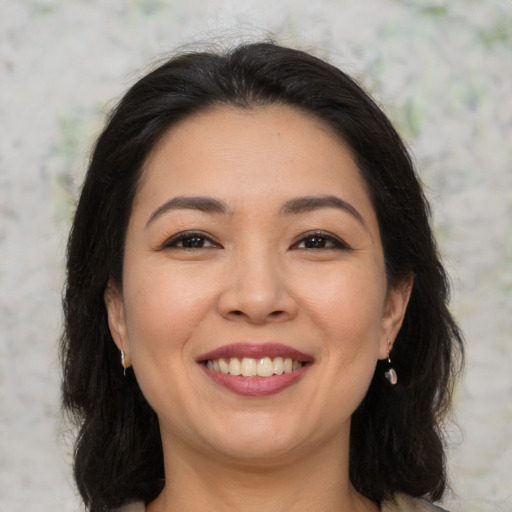 Joyful asian young-adult female with medium  brown hair and brown eyes