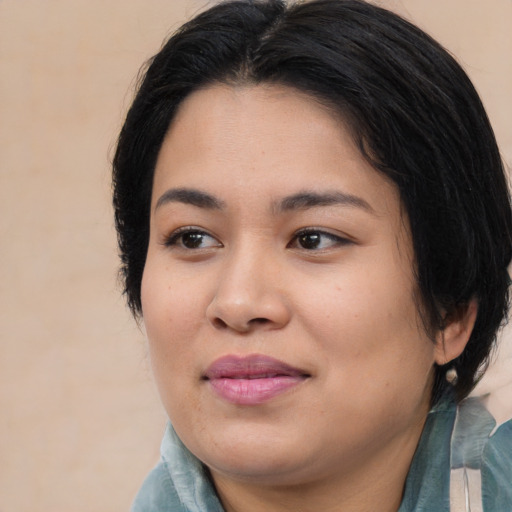 Joyful asian young-adult female with medium  black hair and brown eyes