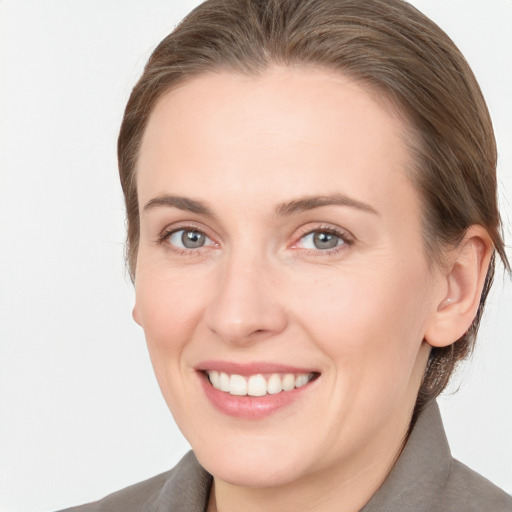 Joyful white young-adult female with medium  brown hair and grey eyes