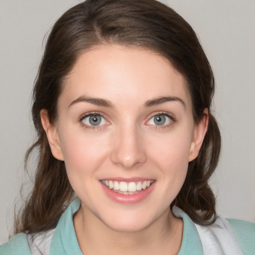 Joyful white young-adult female with medium  brown hair and green eyes