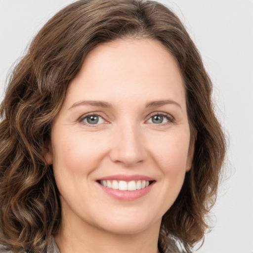 Joyful white young-adult female with medium  brown hair and green eyes