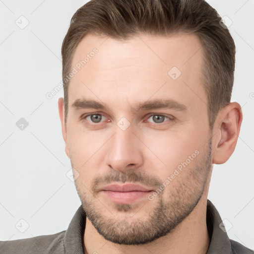 Joyful white young-adult male with short  brown hair and grey eyes