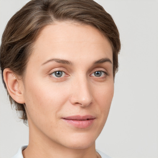 Joyful white young-adult female with short  brown hair and grey eyes