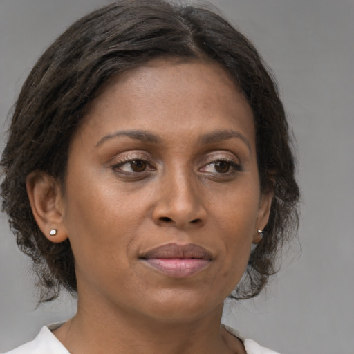 Joyful black adult female with medium  brown hair and brown eyes