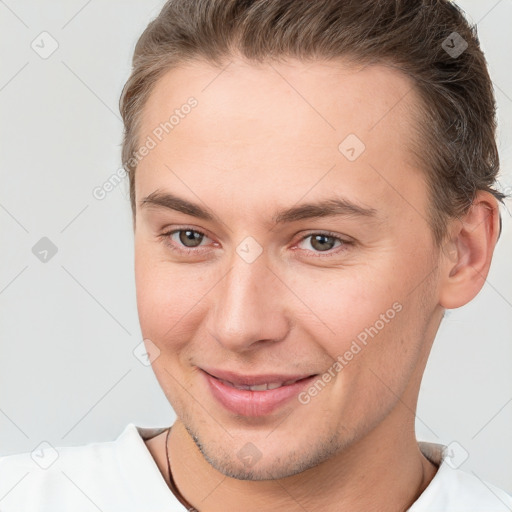 Joyful white young-adult male with short  brown hair and brown eyes