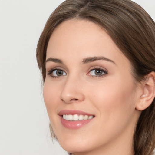 Joyful white young-adult female with medium  brown hair and green eyes