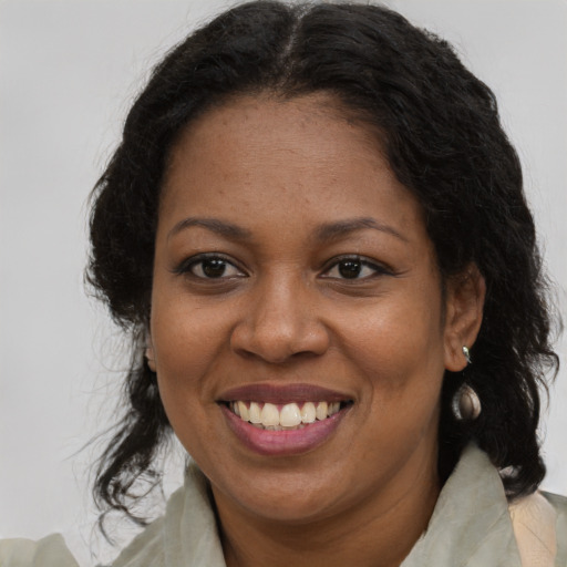Joyful black adult female with long  brown hair and brown eyes