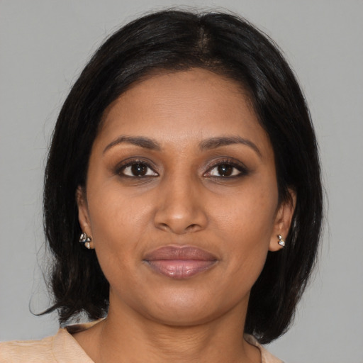 Joyful black young-adult female with medium  brown hair and brown eyes