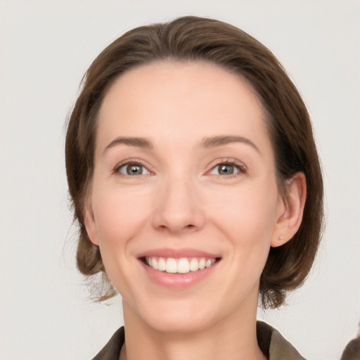 Joyful white young-adult female with medium  brown hair and grey eyes