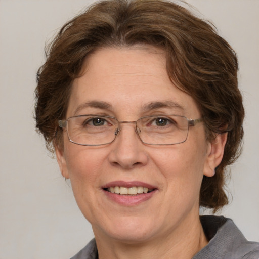 Joyful white middle-aged female with medium  brown hair and grey eyes