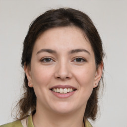 Joyful white young-adult female with medium  brown hair and grey eyes