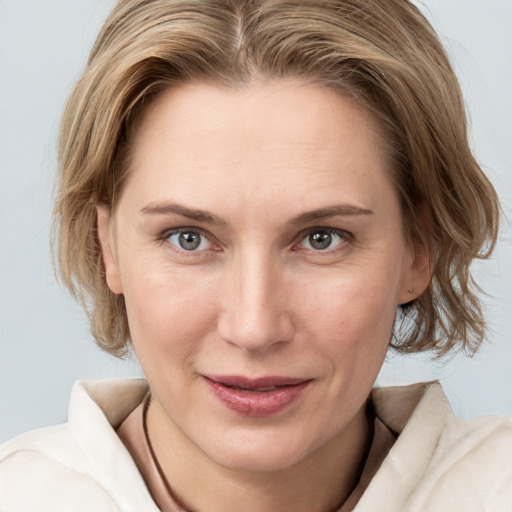 Joyful white young-adult female with medium  brown hair and blue eyes