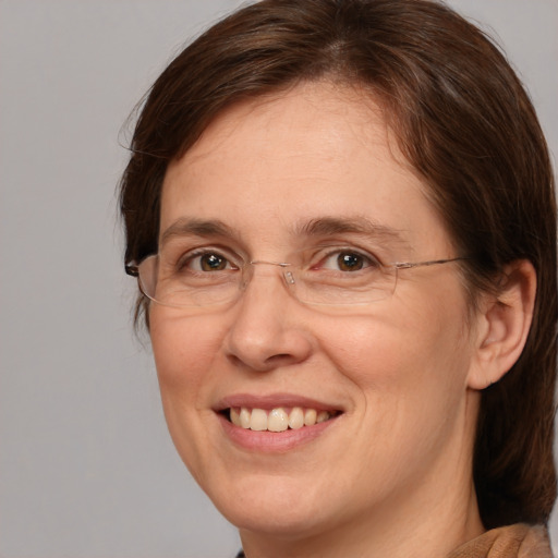 Joyful white adult female with medium  brown hair and grey eyes