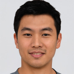 Joyful asian young-adult male with short  black hair and brown eyes