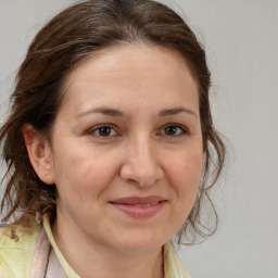 Joyful white adult female with long  brown hair and brown eyes