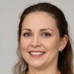 Joyful white adult female with long  brown hair and grey eyes