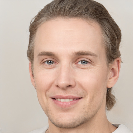 Joyful white adult male with short  brown hair and grey eyes