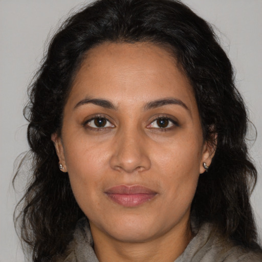 Joyful latino adult female with long  brown hair and brown eyes