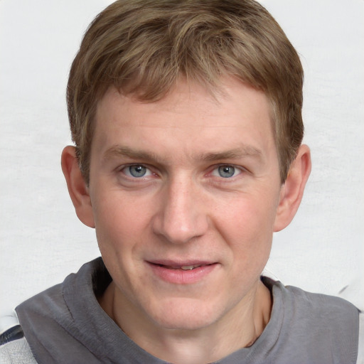 Joyful white young-adult male with short  brown hair and blue eyes