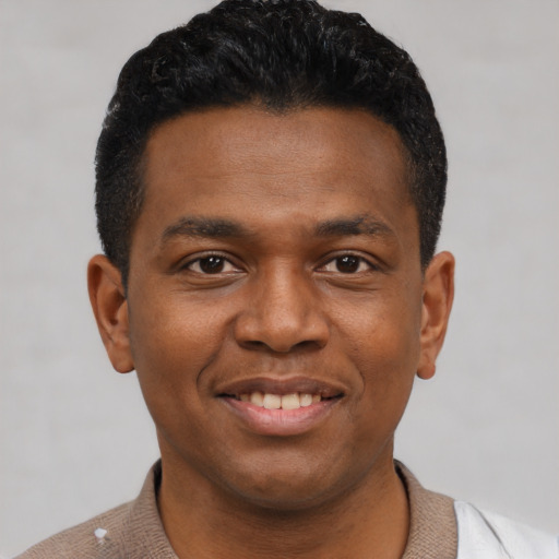 Joyful black young-adult male with short  black hair and brown eyes