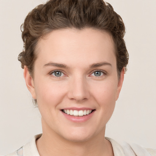 Joyful white young-adult female with short  brown hair and grey eyes