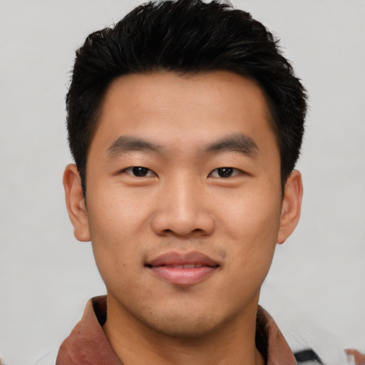 Joyful asian young-adult male with short  black hair and brown eyes