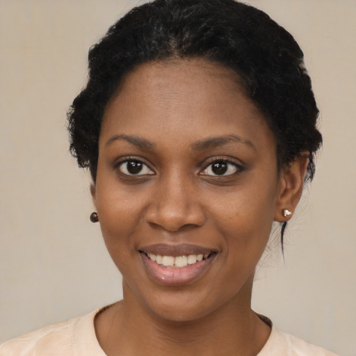 Joyful black young-adult female with short  black hair and brown eyes