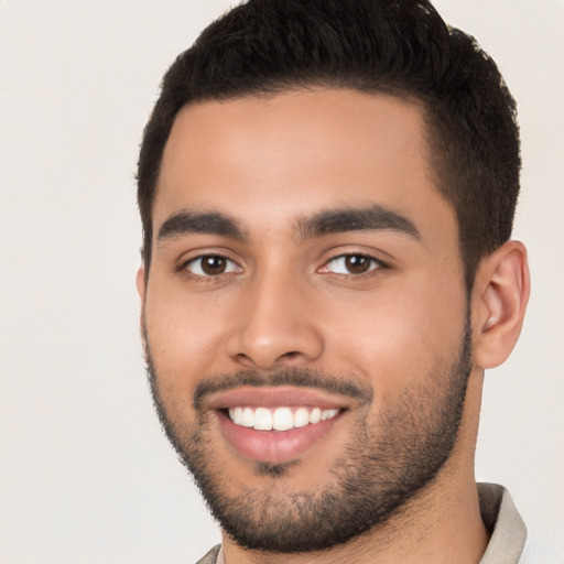 Joyful latino young-adult male with short  black hair and brown eyes