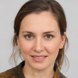 Joyful white young-adult female with medium  brown hair and grey eyes