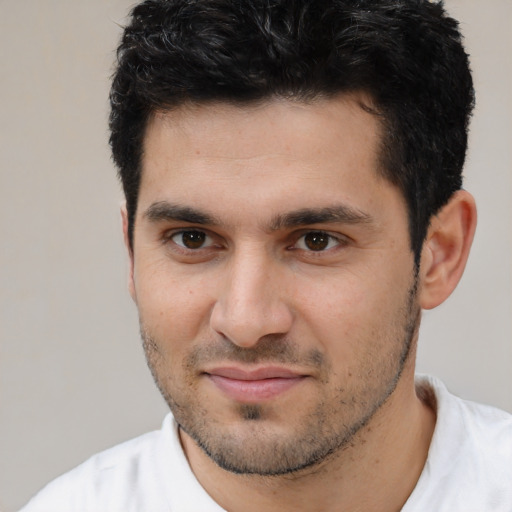 Joyful white young-adult male with short  black hair and brown eyes