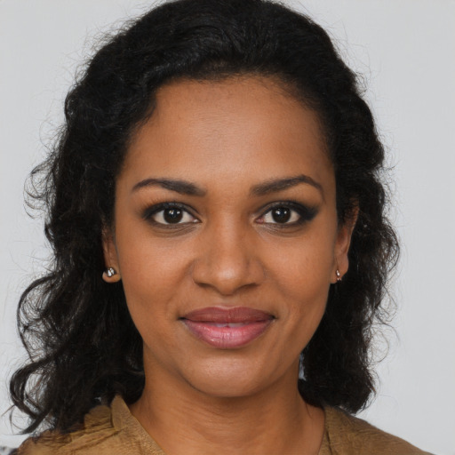 Joyful black young-adult female with long  brown hair and brown eyes