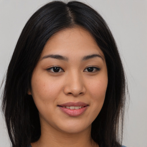 Joyful asian young-adult female with long  brown hair and brown eyes
