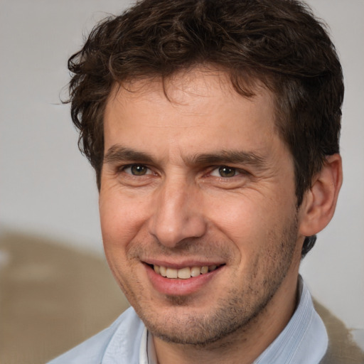 Joyful white adult male with short  brown hair and brown eyes