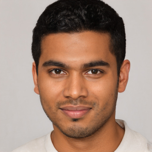 Joyful latino young-adult male with short  black hair and brown eyes