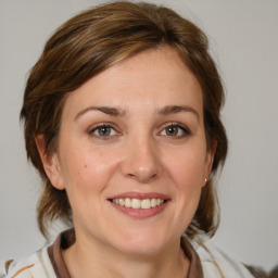 Joyful white young-adult female with medium  brown hair and blue eyes