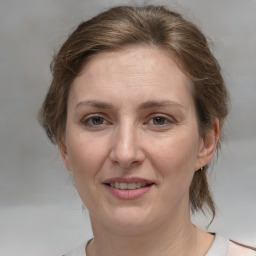 Joyful white adult female with medium  brown hair and brown eyes