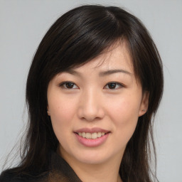 Joyful asian young-adult female with long  brown hair and brown eyes