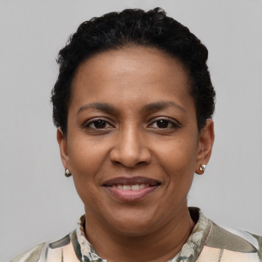 Joyful black young-adult female with short  black hair and brown eyes