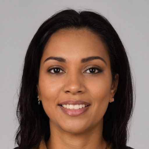 Joyful latino young-adult female with long  brown hair and brown eyes