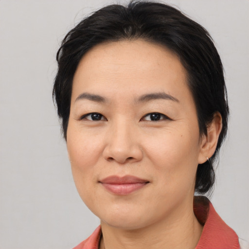 Joyful asian young-adult female with medium  brown hair and brown eyes