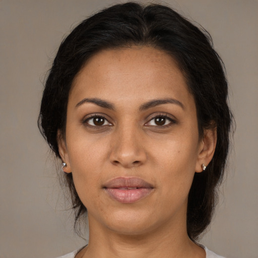 Joyful latino adult female with medium  brown hair and brown eyes