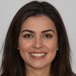 Joyful white young-adult female with long  brown hair and brown eyes